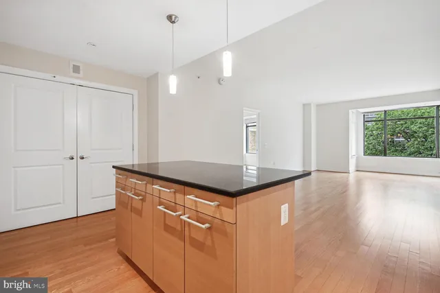 a kitchen with stainless steel appliances granite countertop a sink a stove and a wooden floors