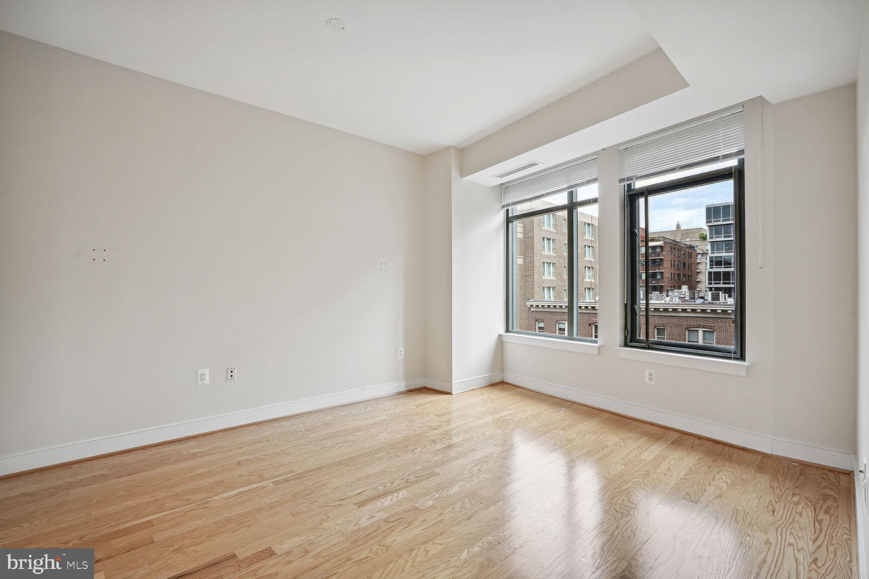 2425 L Street Northwest, Unit 637 Washington, DC 20037 - Photo 9 of 24 a view of an empty room with wooden floor and a window