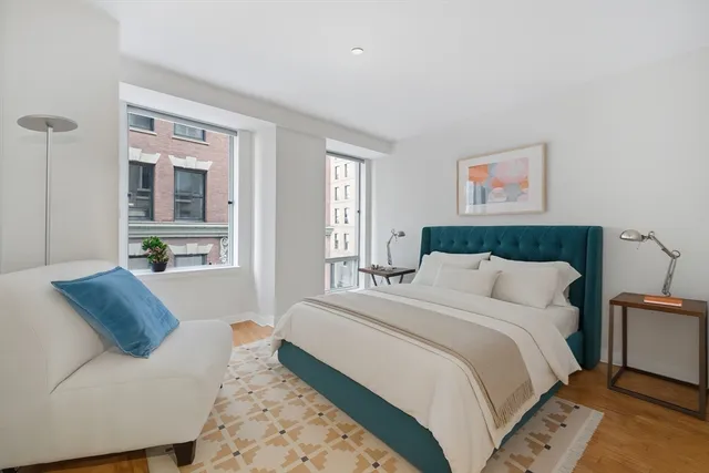 a bedroom with a large bed couch and a window