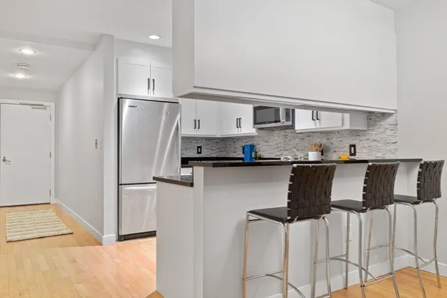 a kitchen with stainless steel appliances granite countertop a refrigerator and a stove
