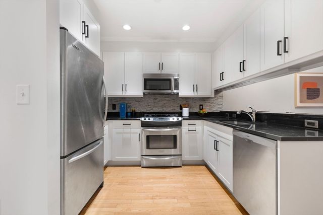a kitchen with stainless steel appliances granite countertop a stove a refrigerator and a microwave