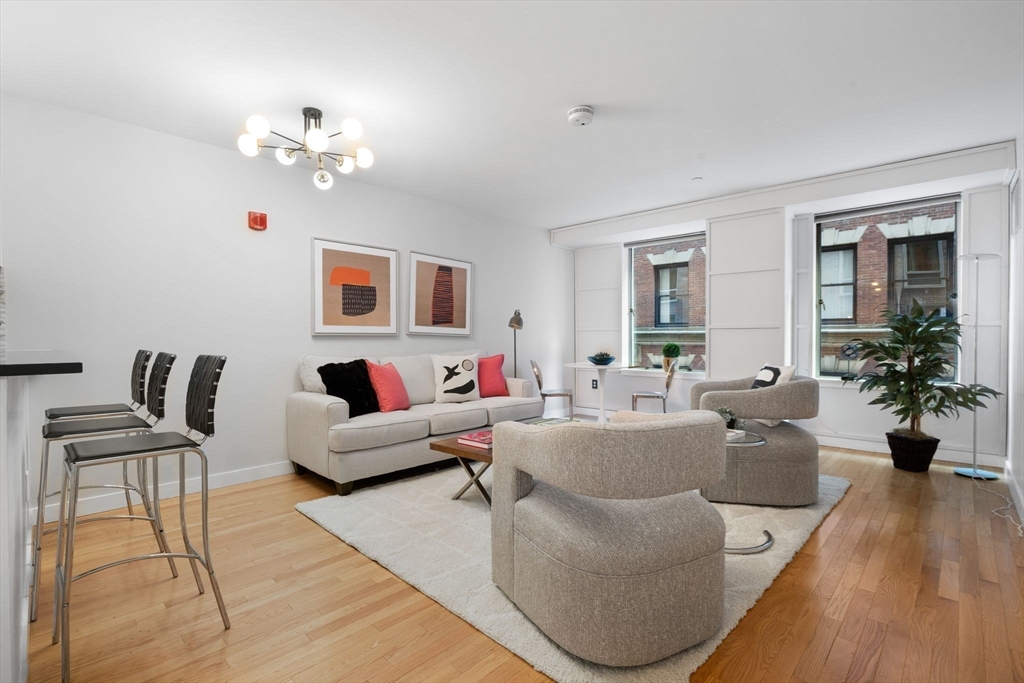80 Broad Street, Unit 303 Boston, MA 02110 - Photo 4 of 23 a living room with furniture and wooden floor
