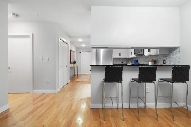 a kitchen with stainless steel appliances kitchen island granite countertop a table and chairs in it