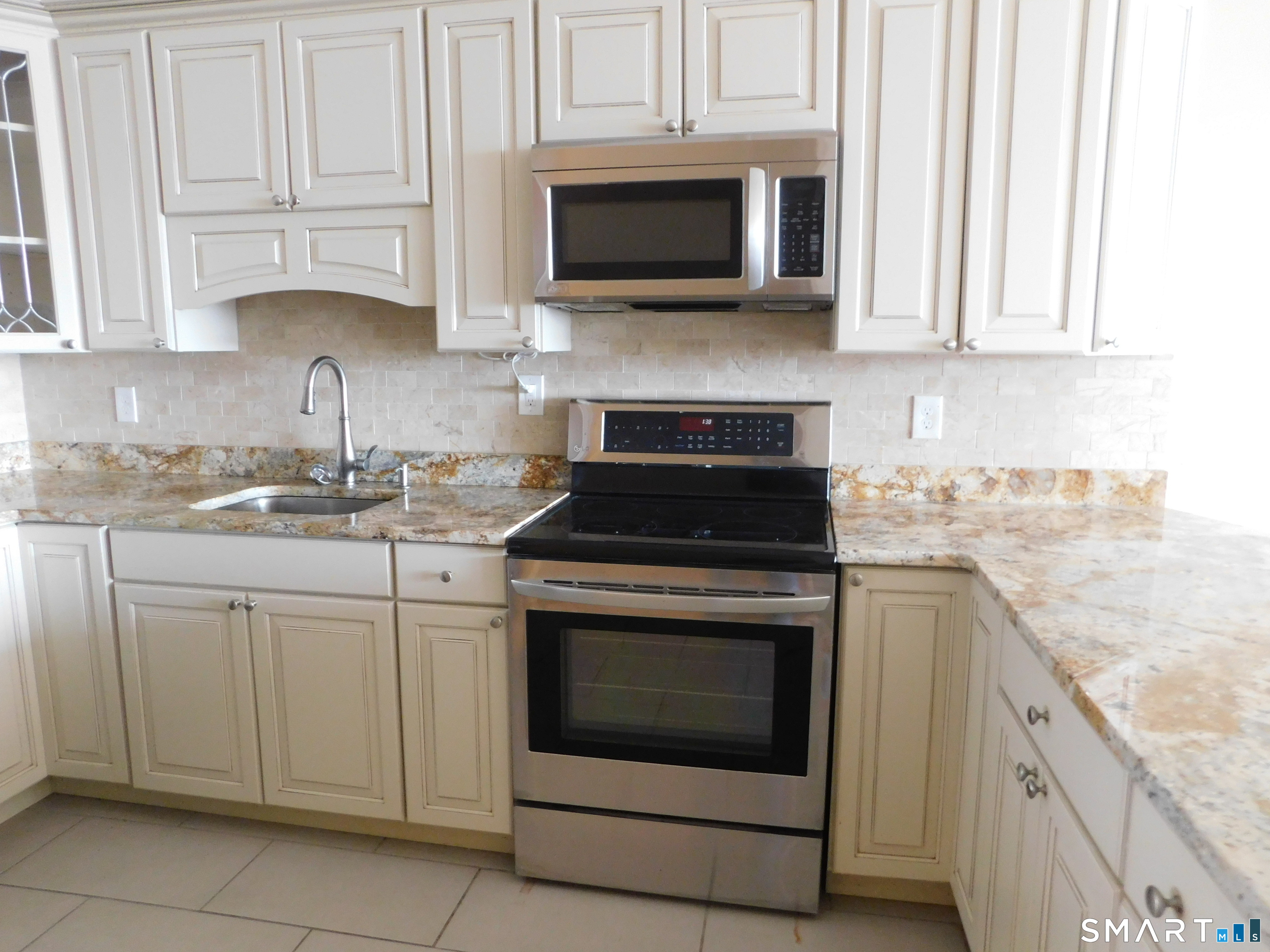 153 Bank Street, Unit 203 New London, CT 06320 - Photo 2 of 10 a kitchen with cabinets stainless steel appliances granite countertop white cabinets granite counter tops and a wooden floors