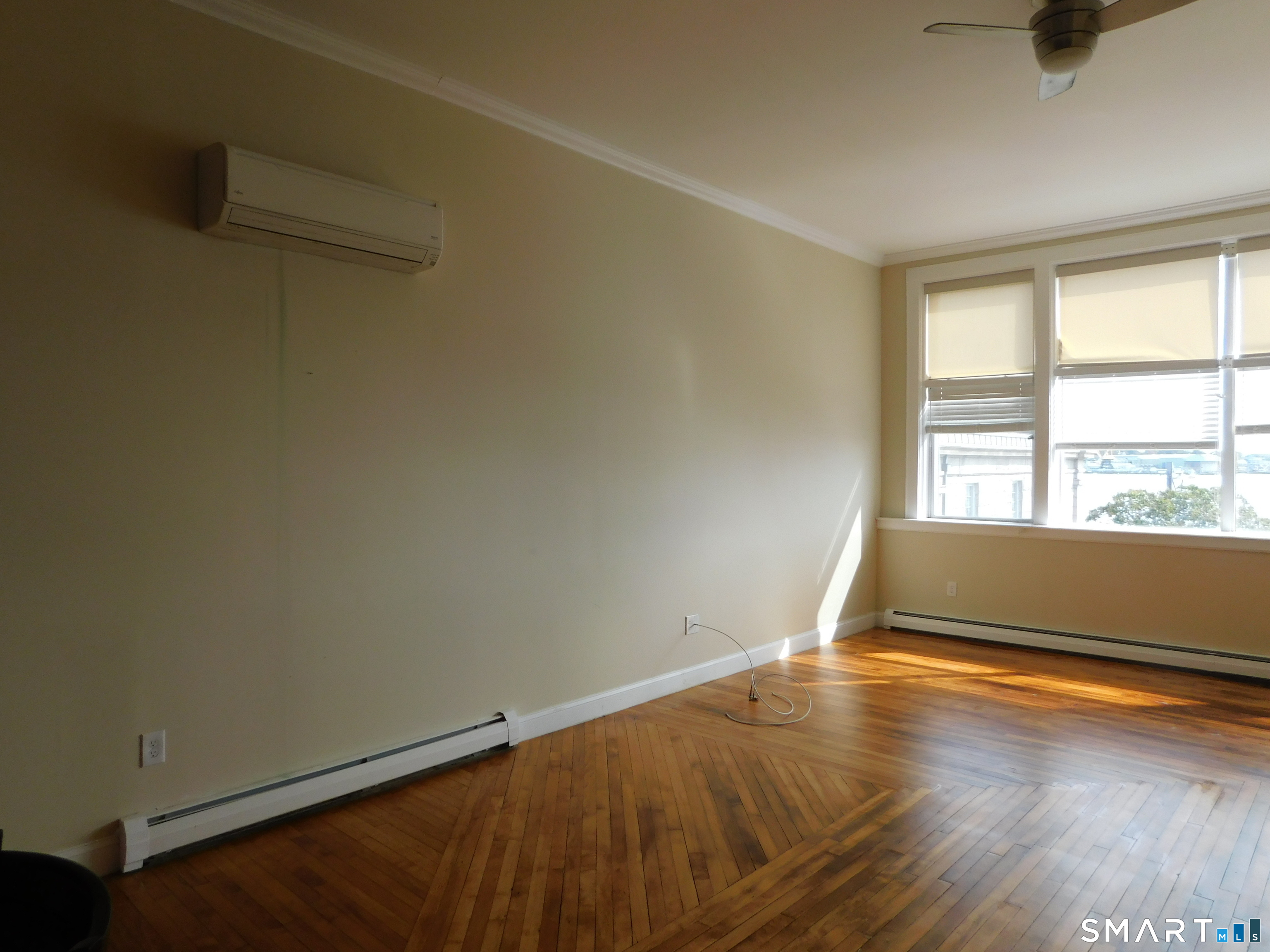 153 Bank Street, Unit 203 New London, CT 06320 - Photo 5 of 10 an empty room with wooden floor and windows