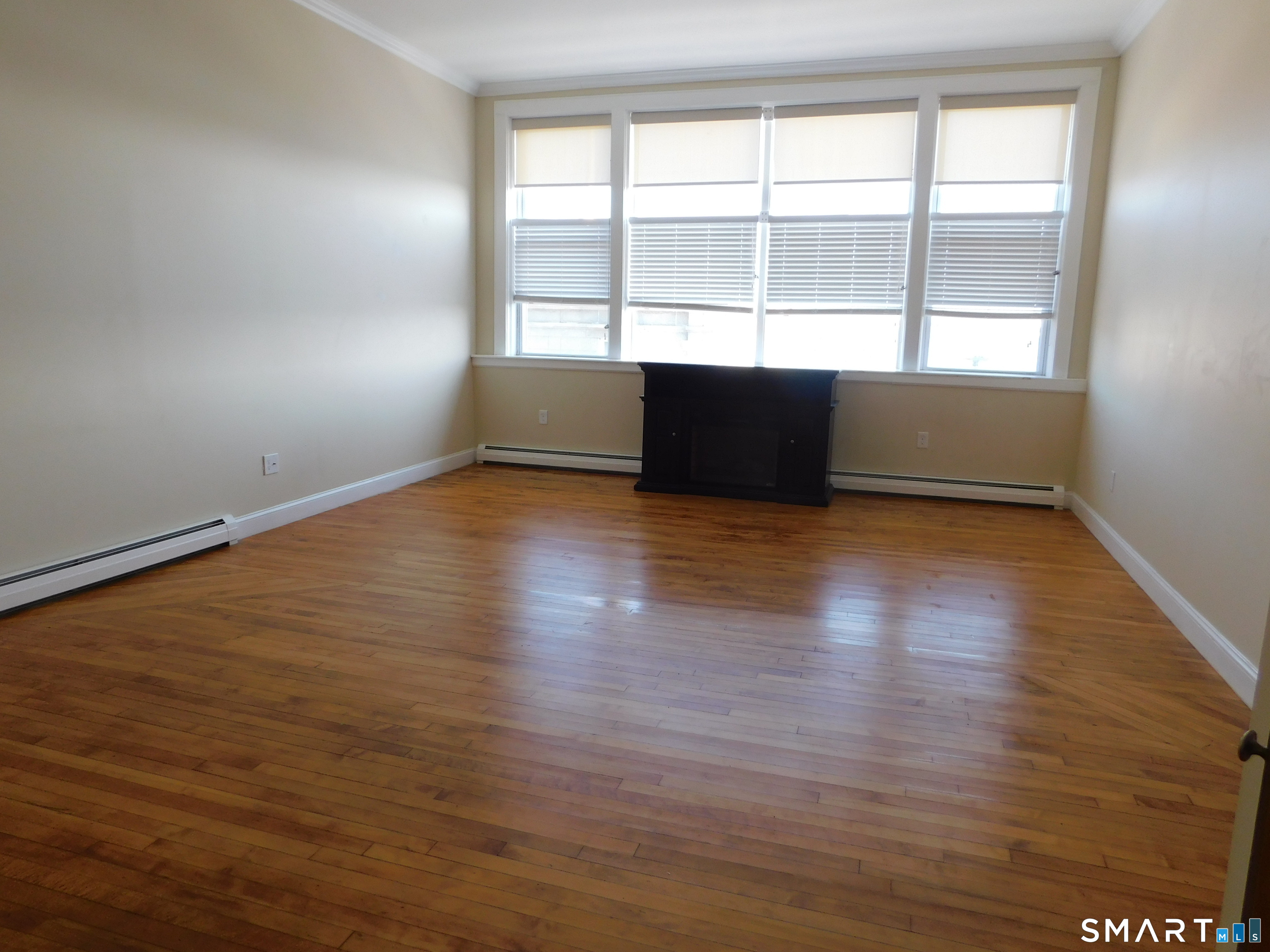 153 Bank Street, Unit 203 New London, CT 06320 - Photo 6 of 10 an empty room with wooden floor and windows