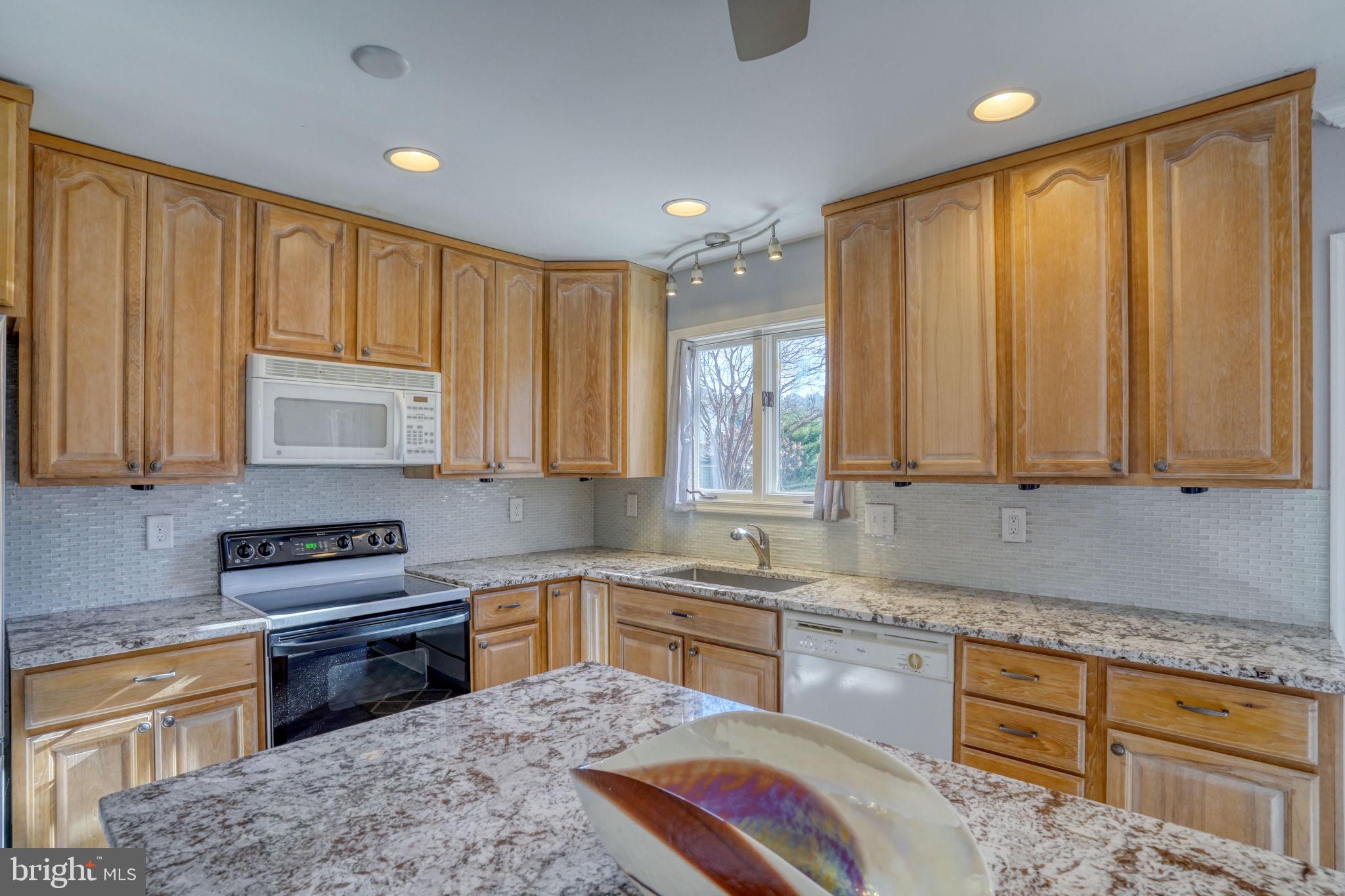 34772 Frontier Road Lewes, DE 19958 - Photo 13 of 66 a kitchen with kitchen island granite countertop a sink window and cabinets