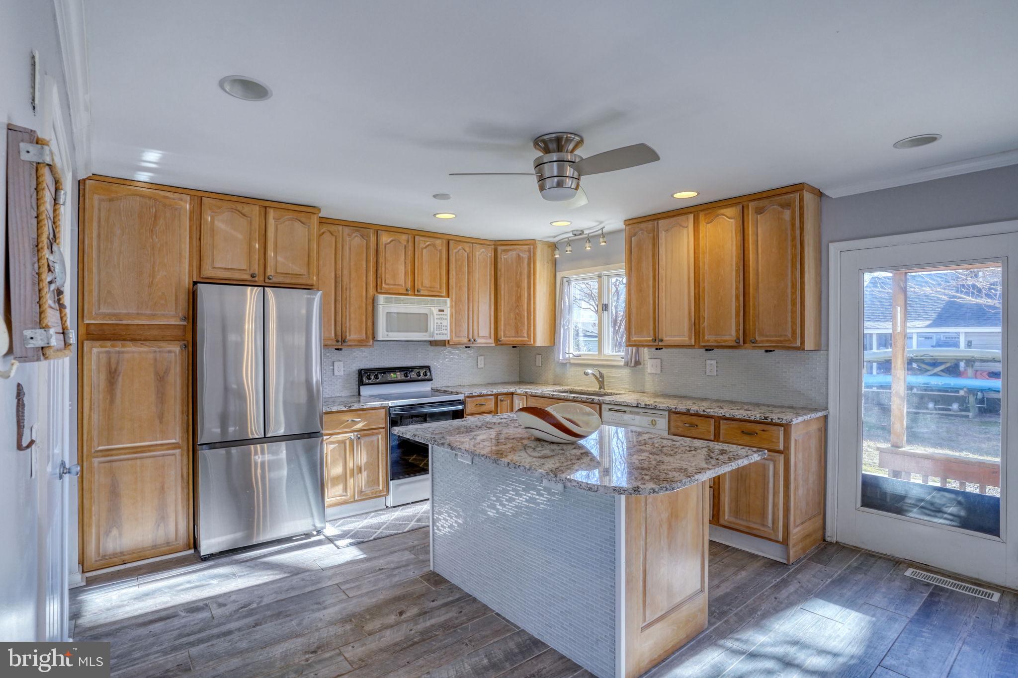34772 Frontier Road Lewes, DE 19958 - Photo 15 of 66 a kitchen with wooden cabinets and stainless steel appliances