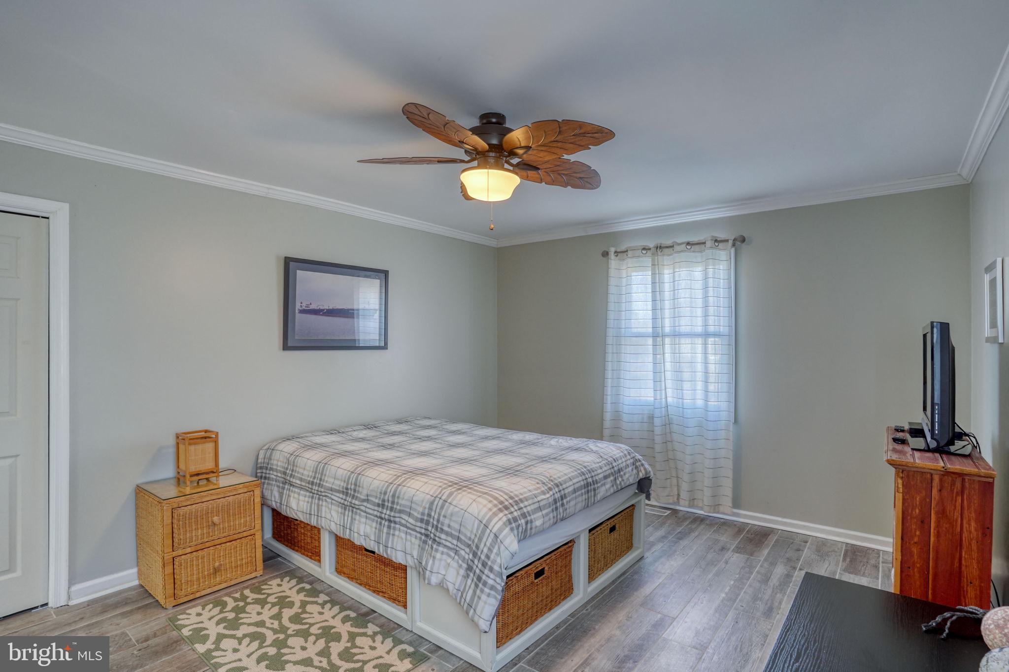 34772 Frontier Road Lewes, DE 19958 - Photo 26 of 66 a bedroom with a bed and a chandelier
