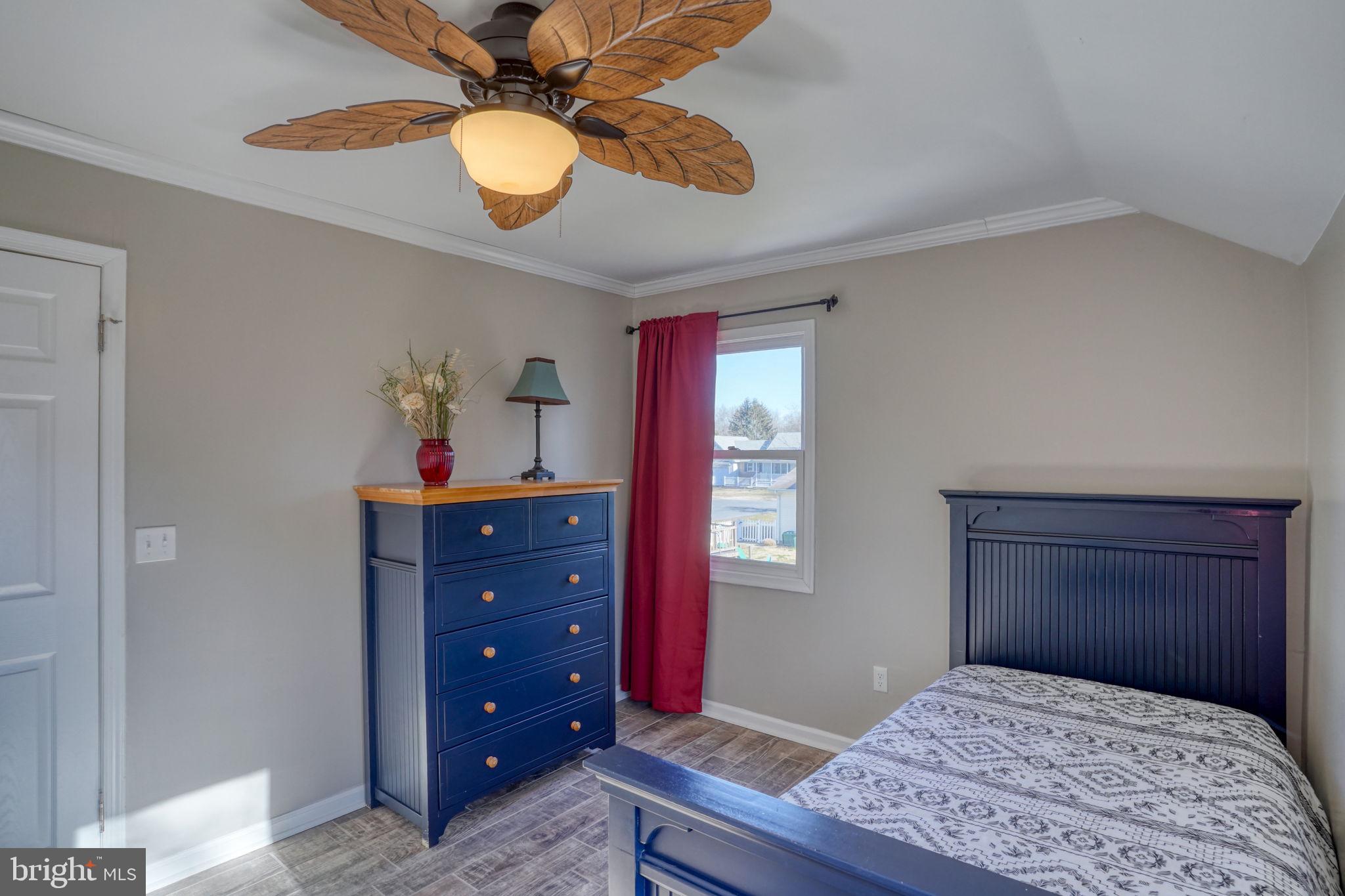 34772 Frontier Road Lewes, DE 19958 - Photo 30 of 66 a bedroom with a bed and a chandelier