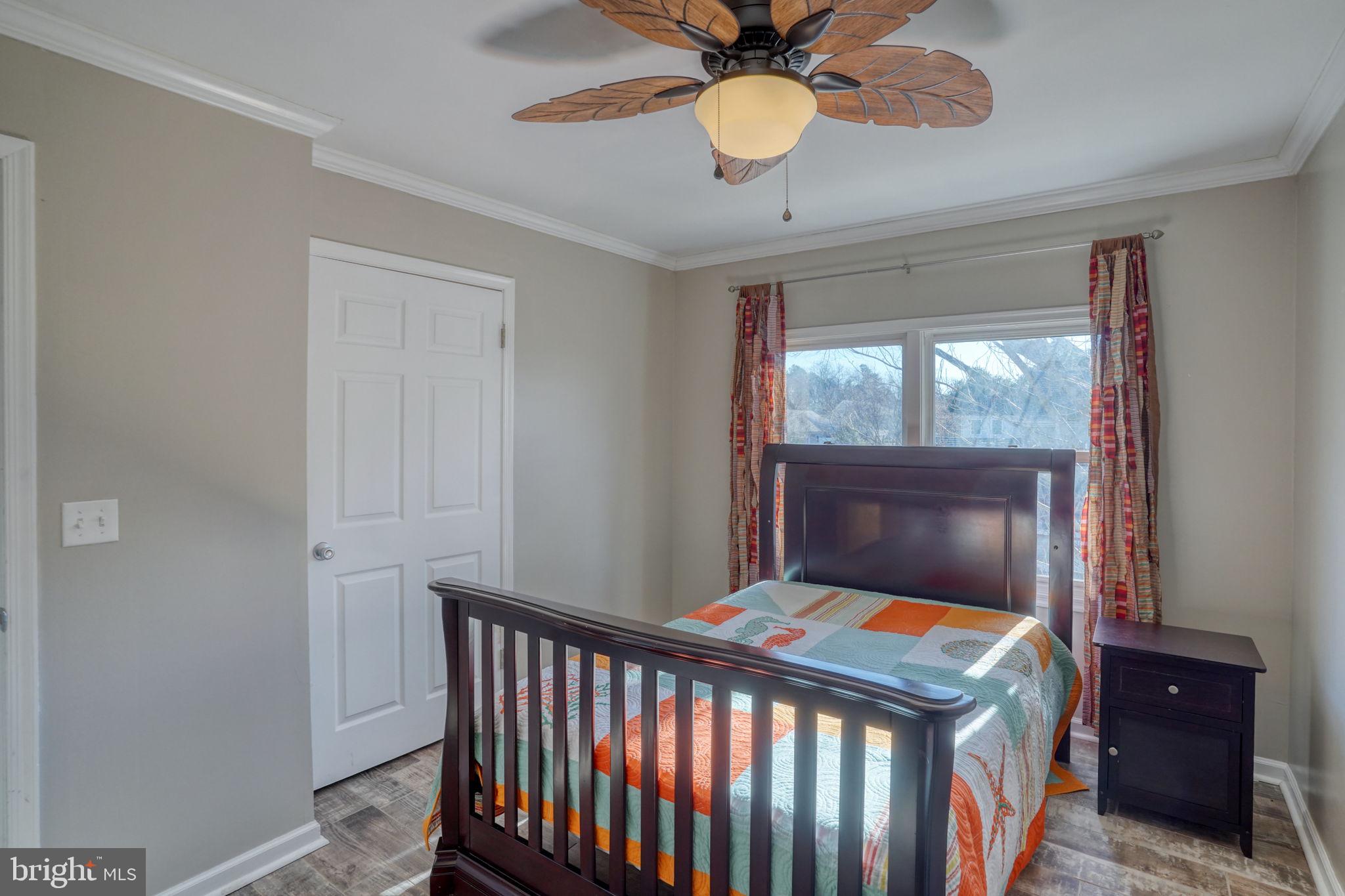 34772 Frontier Road Lewes, DE 19958 - Photo 32 of 66 a bedroom with a bed and a chandelier