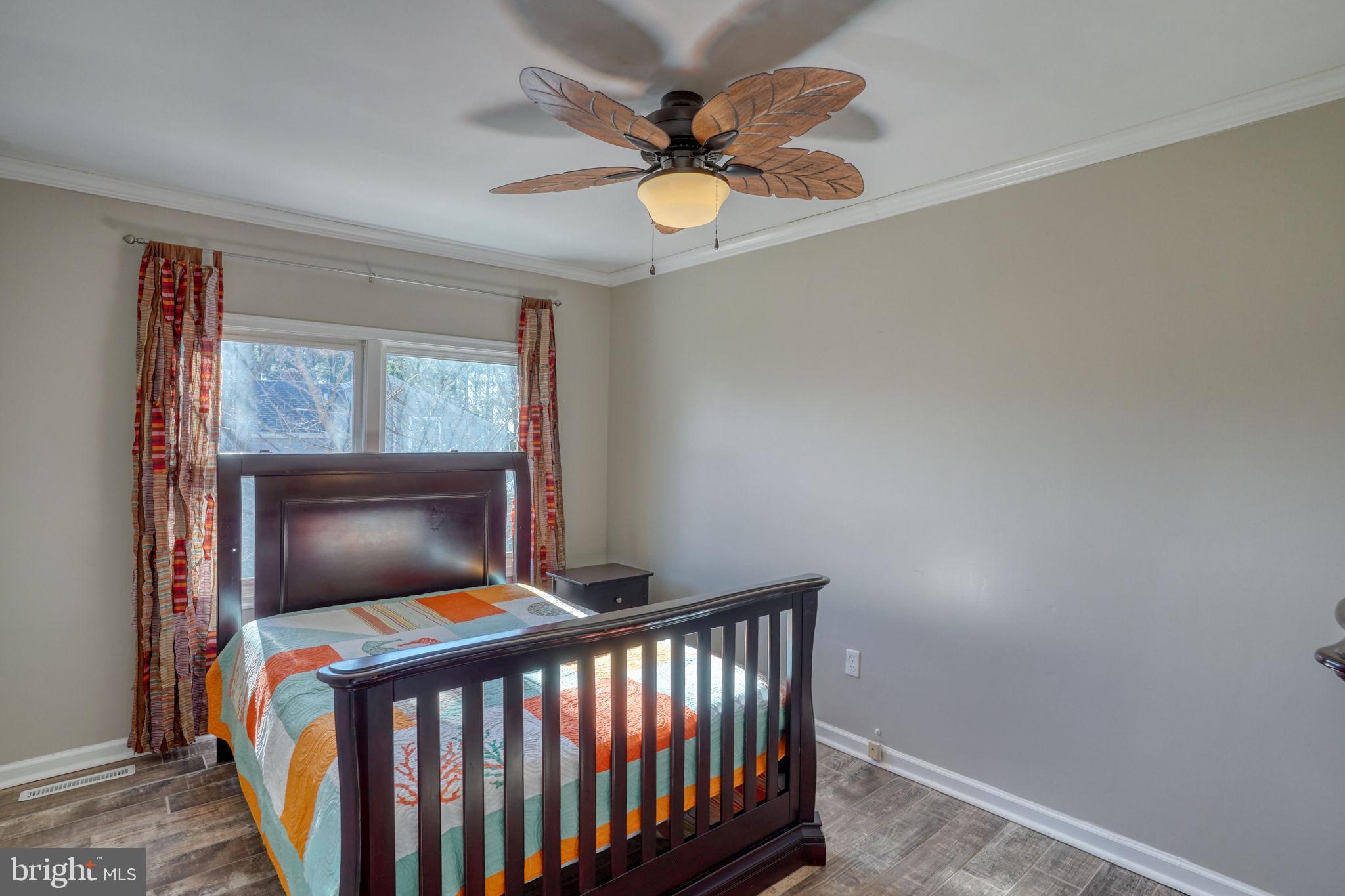 34772 Frontier Road Lewes, DE 19958 - Photo 33 of 66 a bedroom with a bed and a chandelier
