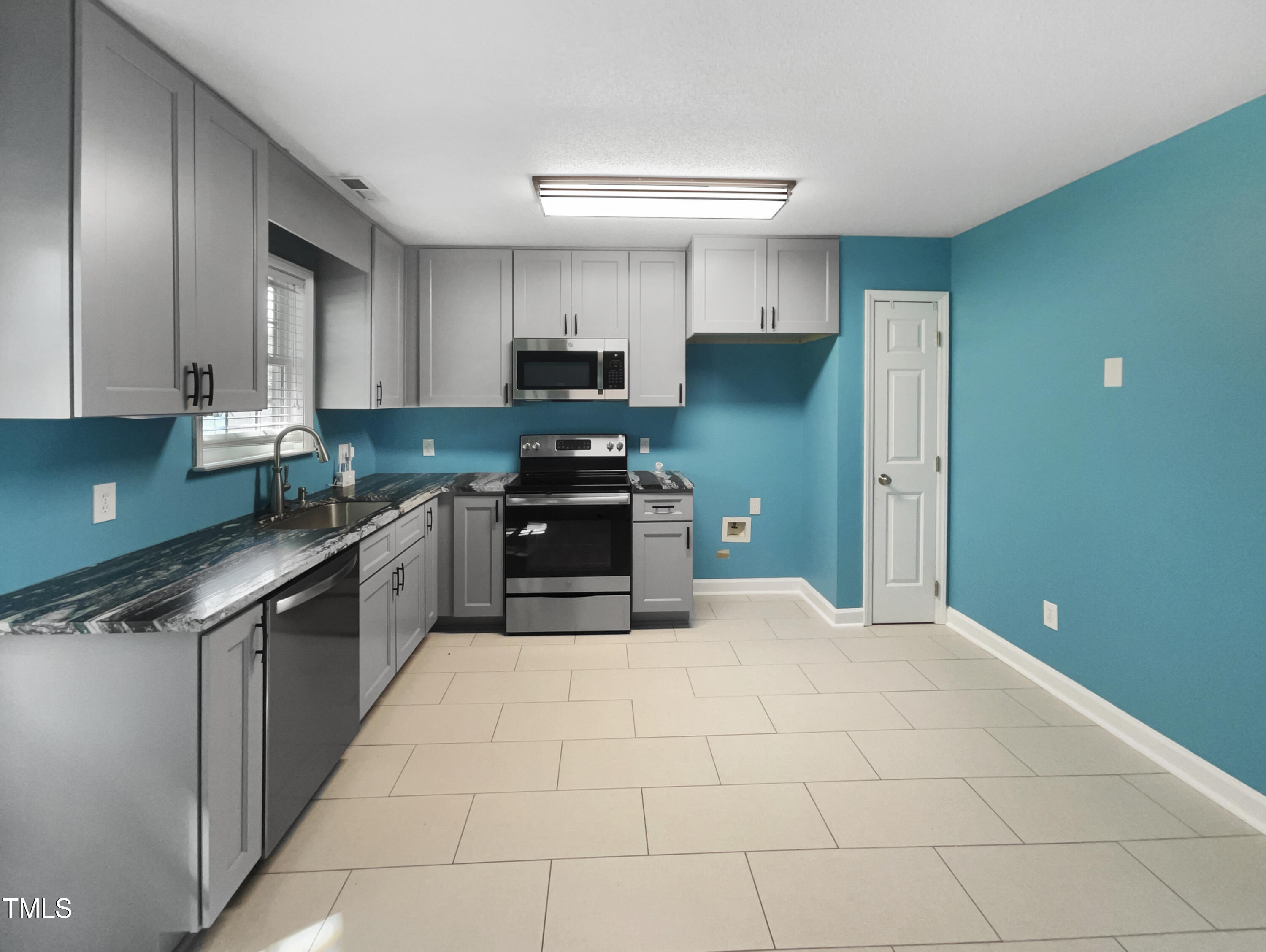 1661 Lee Road Clayton, NC 27520 - Photo 4 of 15 a kitchen with stainless steel appliances a refrigerator sink and cabinets
