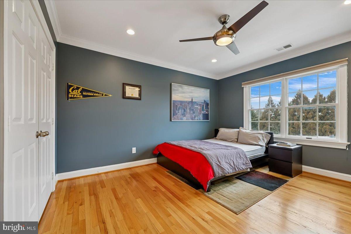 9917 Kendale Road Potomac, MD 20854 - Photo 18 of 39 a bedroom with a large bed and a chandelier