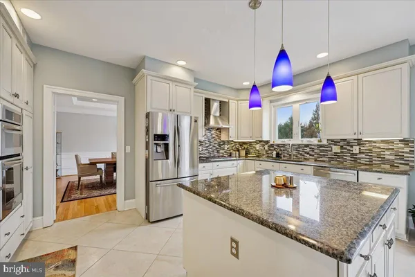 a kitchen with stainless steel appliances granite countertop a sink and a refrigerator