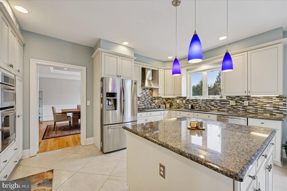 9917 Kendale Road Potomac, MD 20854 - Photo 6 of 39 a kitchen with stainless steel appliances granite countertop a sink and a refrigerator