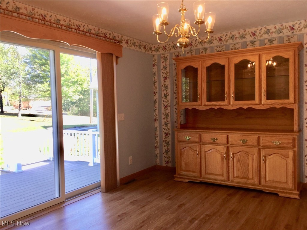 5100 Ellerman Road Zanesville, OH 43701 - Photo 13 of 46 Unfurnished dining area with a chandelier, dark wood-style flooring, and wallpapered walls