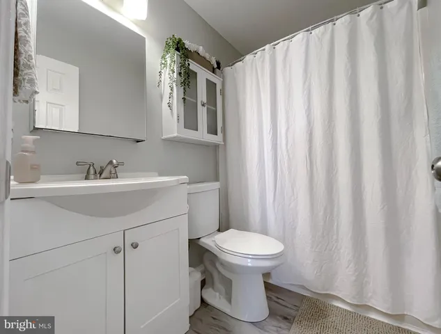 a bedroom with a bed and a flat tv screen on dresser