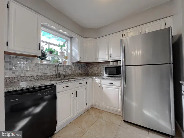 a kitchen with appliances a sink and a refrigerator