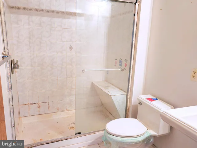 a white toilet sitting next to a bath tub