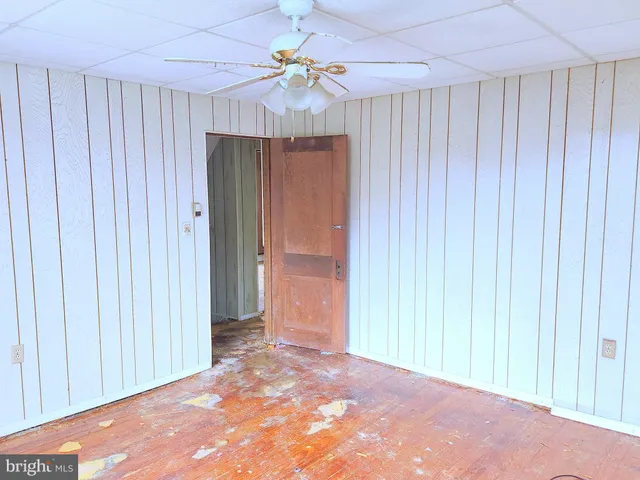 an empty room with a ceiling fan and closet area