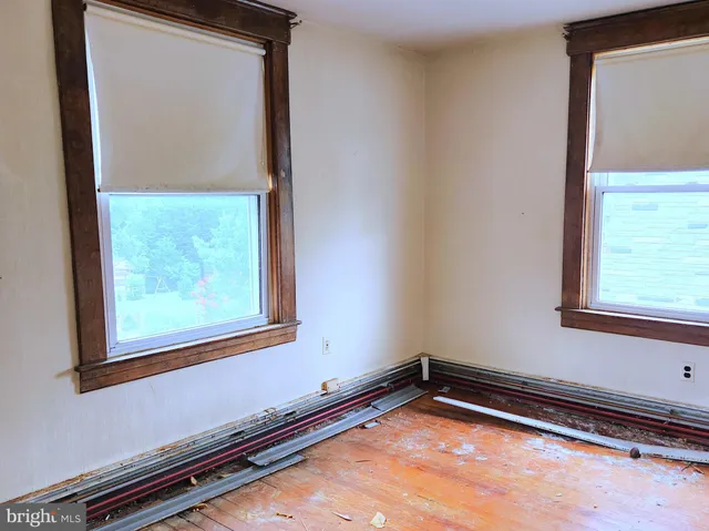 a view of a room with wooden floor and a window