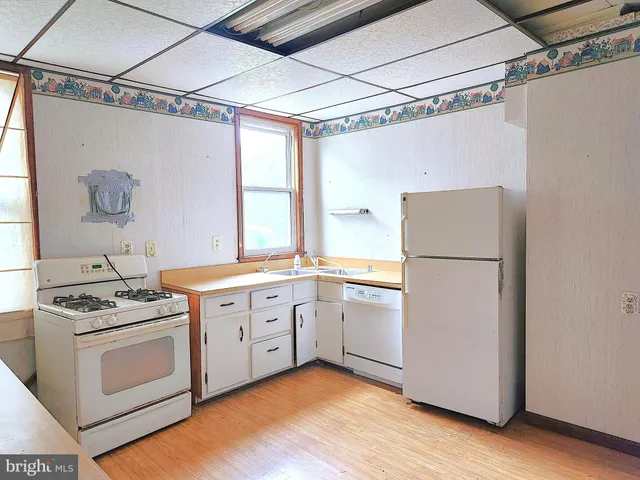 a kitchen with white cabinets and white appliances