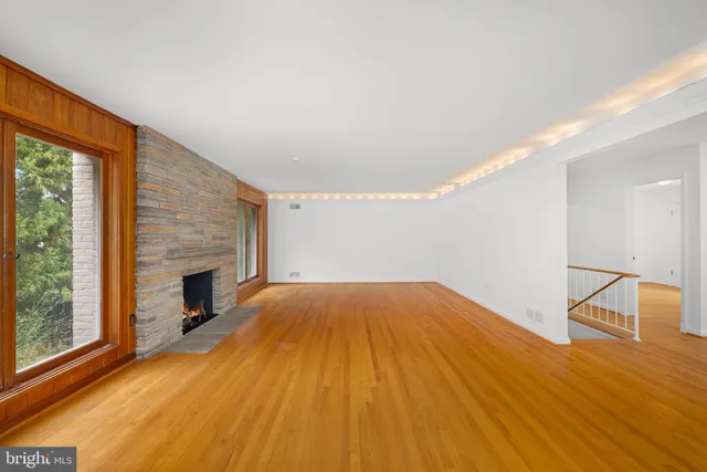 a view of empty room with wooden floor and fireplace