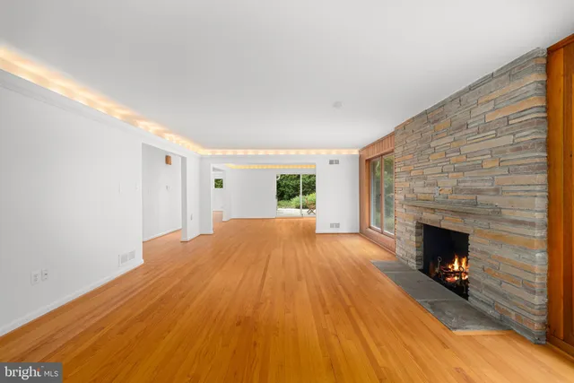 a view of empty room with fireplace and wooden floor