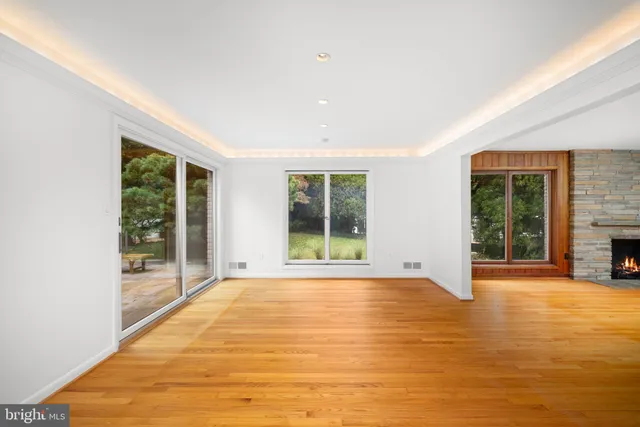 a view of an empty room with a fireplace and a large window