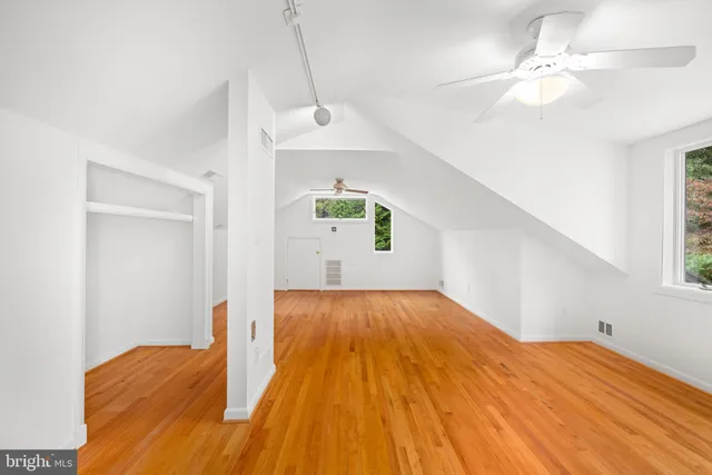 a view of empty room with wooden floor
