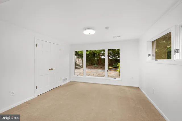 a view of a big room with windows and chandelier fan