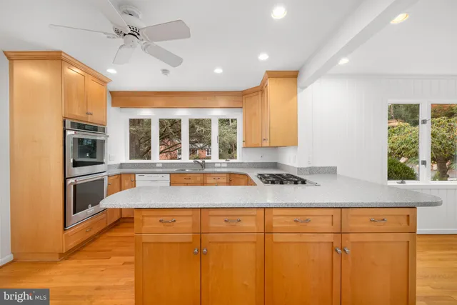 a kitchen with stainless steel appliances granite countertop a sink a stove and a refrigerator