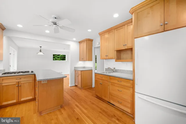 a kitchen with stainless steel appliances granite countertop a sink a stove and a refrigerator