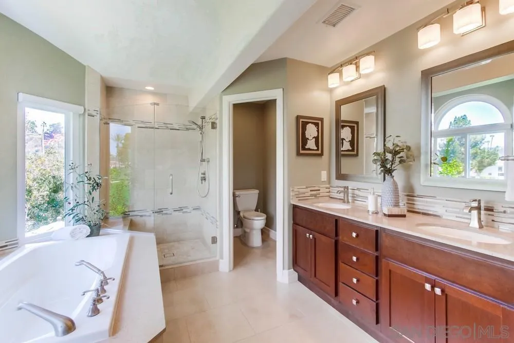 16101 Via Madera Circa West Rancho Santa Fe, CA 92091 - Photo 26 of 56 a spacious bathroom with a double vanity sink a large mirror a bathtub and shower