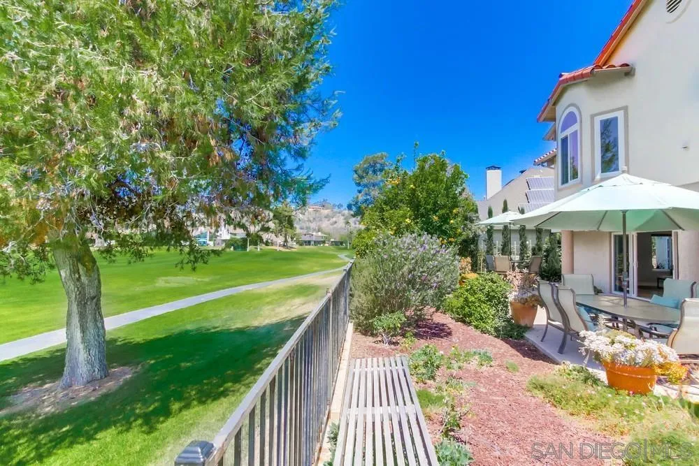 16101 Via Madera Circa West Rancho Santa Fe, CA 92091 - Photo 39 of 56 a view of a patio with a table chairs under an umbrella with large trees
