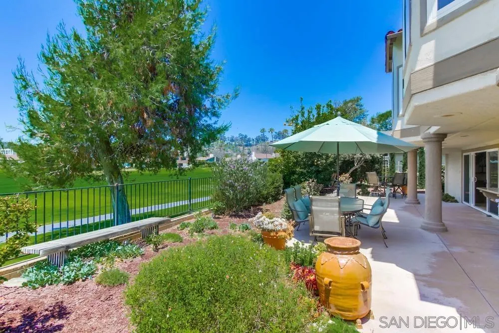 16101 Via Madera Circa West Rancho Santa Fe, CA 92091 - Photo 4 of 56 a view of a patio with chairs and a table under an umbrella