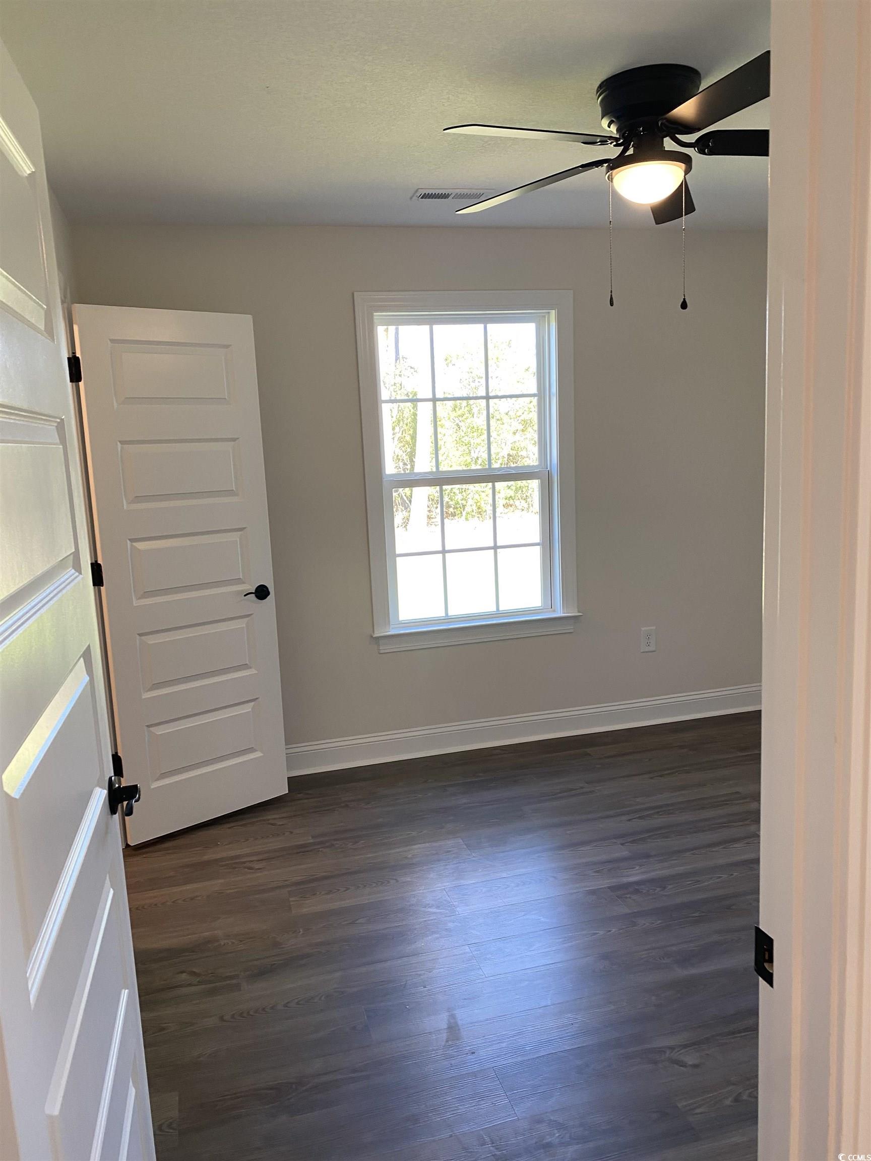 3397 Dusty Road Loris, SC 29569 - Photo 4 of 10 Spare room with ceiling fan and dark hardwood / wo
