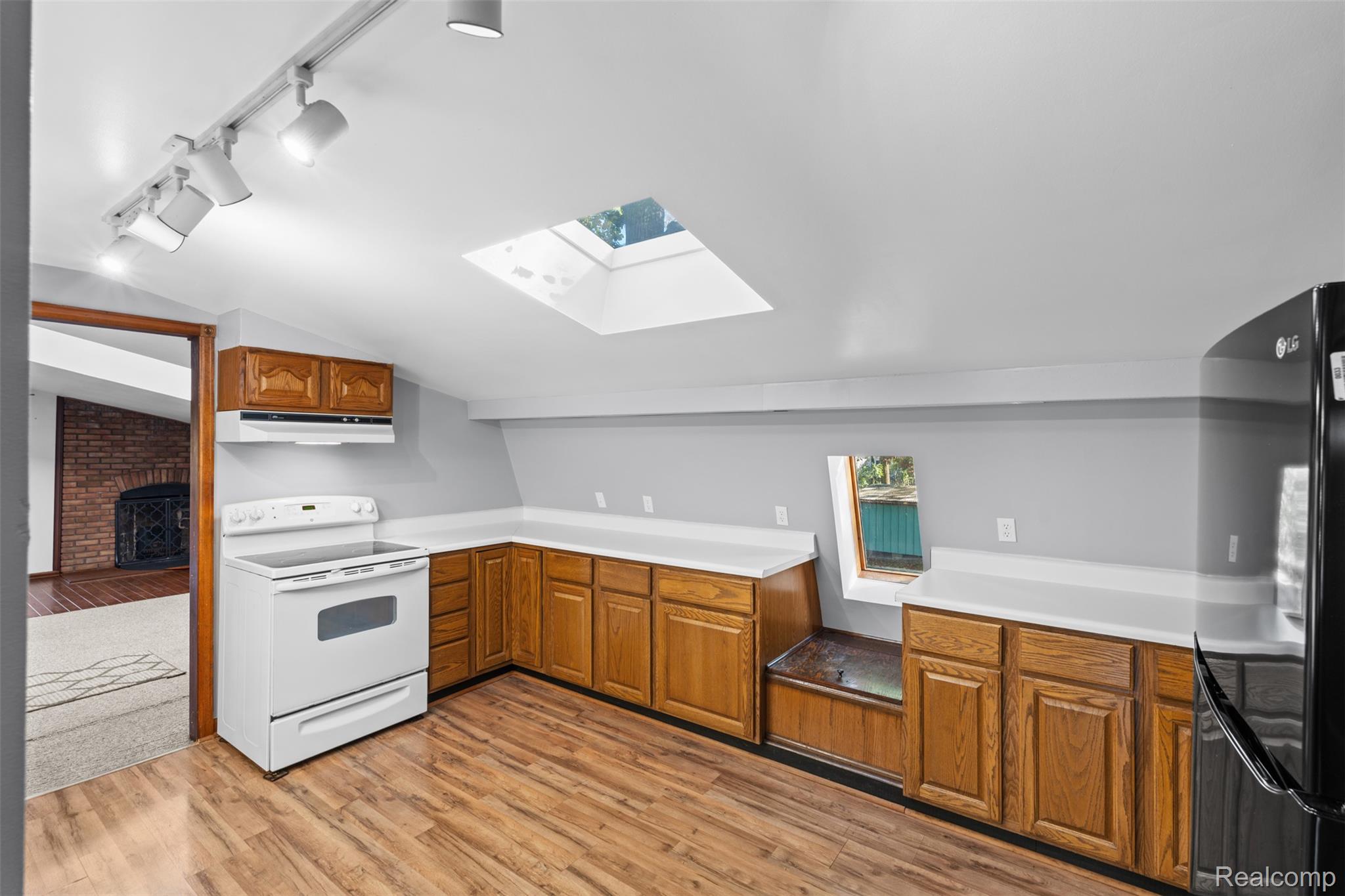 7670 Mi State Road Manchester, MI 48158 - Photo 20 of 53 Kitchen with lofted ceiling, white electric stove, track lighting, a skylight, and freestanding refrigerator