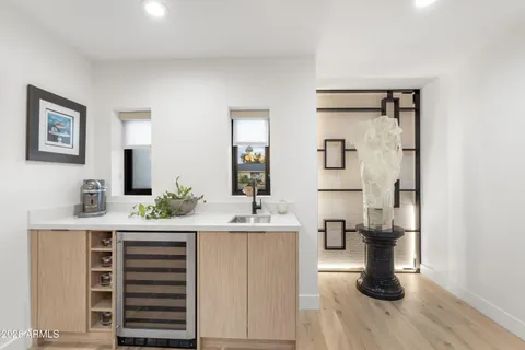 a kitchen with stainless steel appliances granite countertop a sink a stove a refrigerator and white cabinets with wooden floor