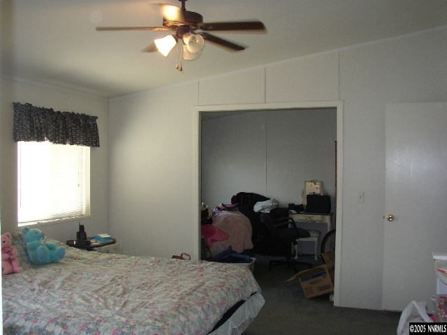 6135 Jacobs Road Fallon, NV 89406 - Photo 8 of 9 a bedroom with a bed and a chandelier