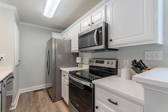 a kitchen with stainless steel appliances white cabinets and a stove