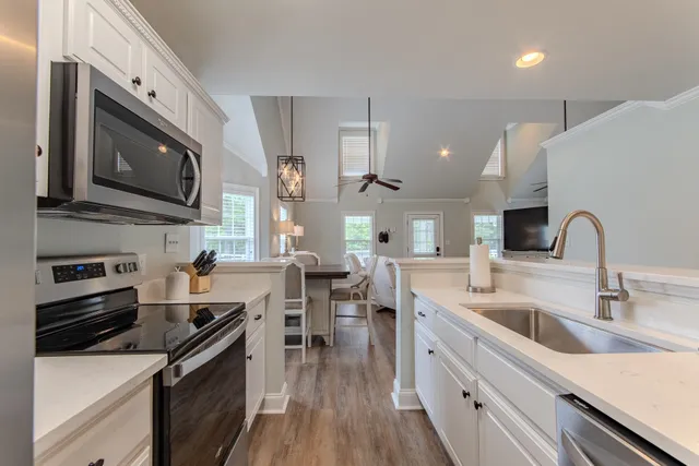 a kitchen with stainless steel appliances a sink a stove top oven a counter space and cabinets