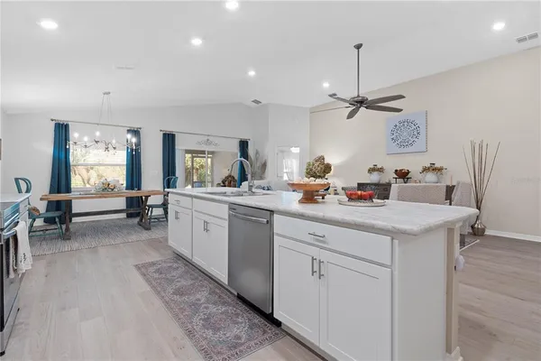 a large kitchen with stainless steel appliances granite countertop a lot of counter space and wooden floors