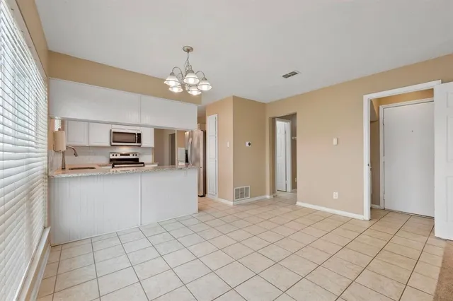 a view of a kitchen with stainless steel appliances granite countertop a refrigerator and a stove top oven