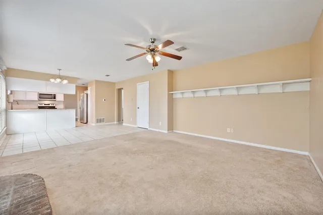 a view of a livingroom with a ceiling fan and window