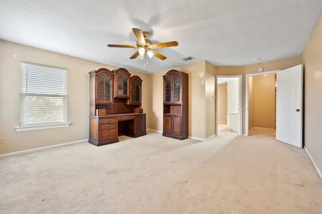 a view of a livingroom with a ceiling fan and window