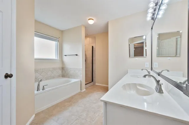 a bathroom with a tub sink and mirror