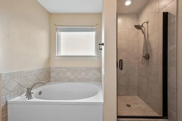 a white bath tub sitting next to a shower