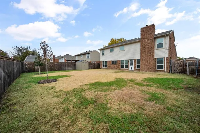 a view of a house with a big yard and a large tree